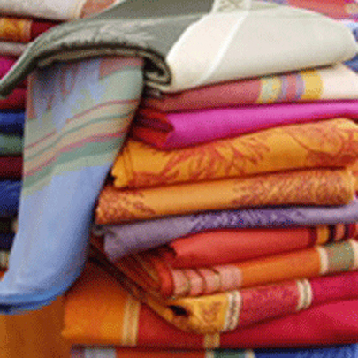 A stack of brightly colored French Jacquard Tea Towels