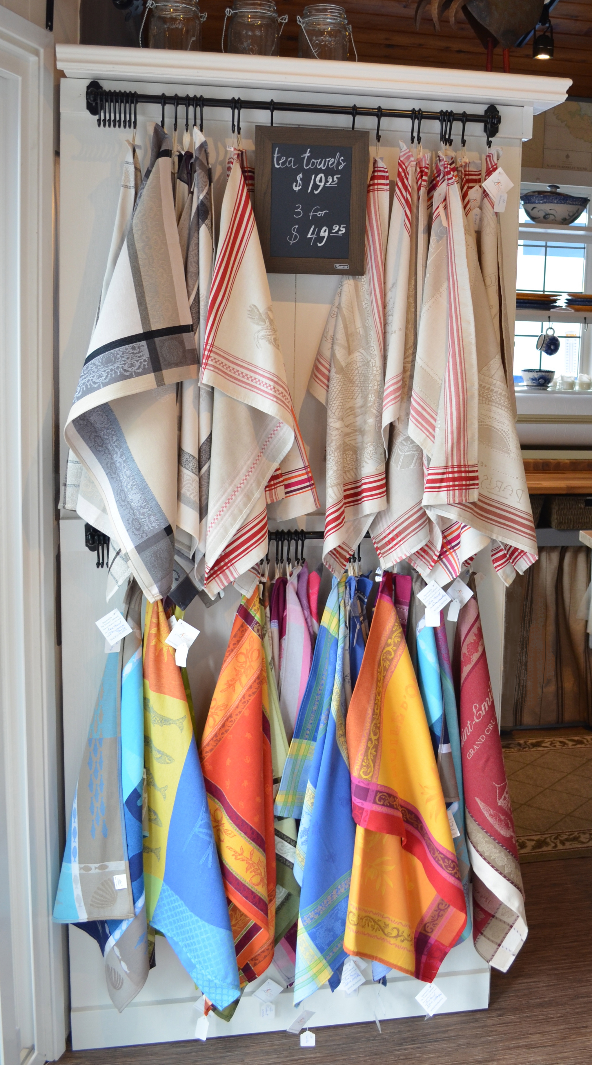 French Jacquard Tea Towels displayed hanging on the hooks inside 4 Winds Nest Artisans - our store in Victoria, BC